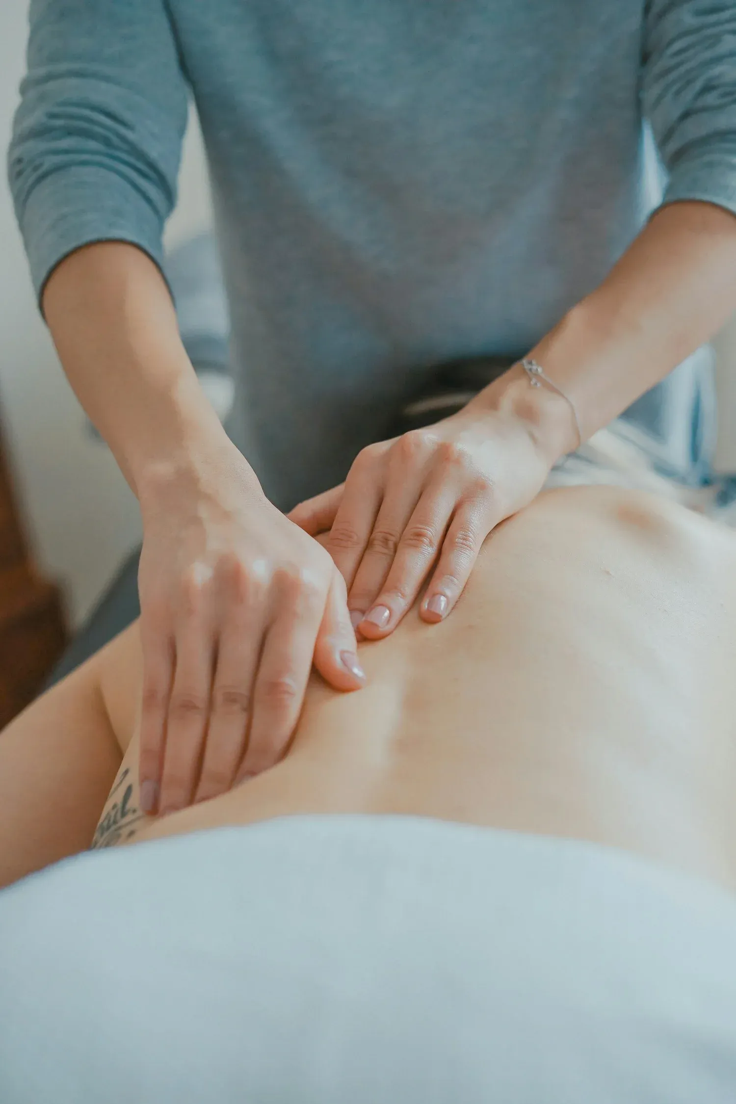 A massage therapist's hands working on a client's back