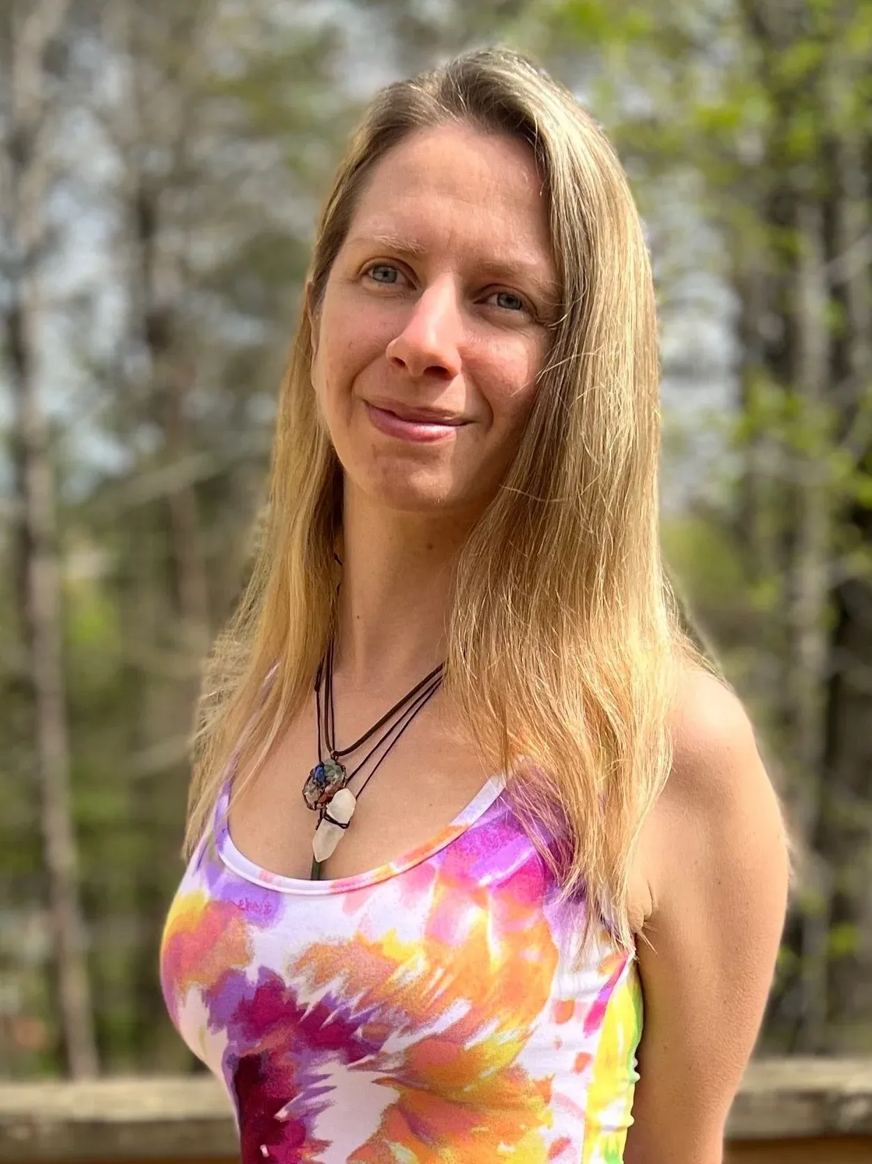 Jillian Ricks in a colorful tie-dye top among the trees