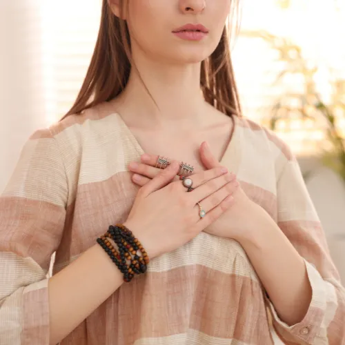 A woman resting both hands gently over her heart