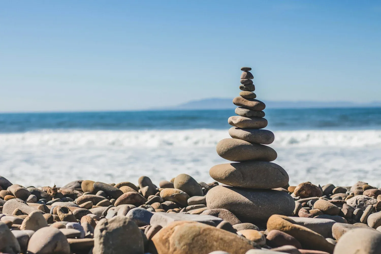 Smooth stones stacked into a cairn on a pebble beach